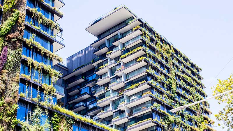 Prédio sustentável com fachadas cobertas por jardins verticais em Sydney, exemplo de eficiência energética passiva e arquitetura ecológica