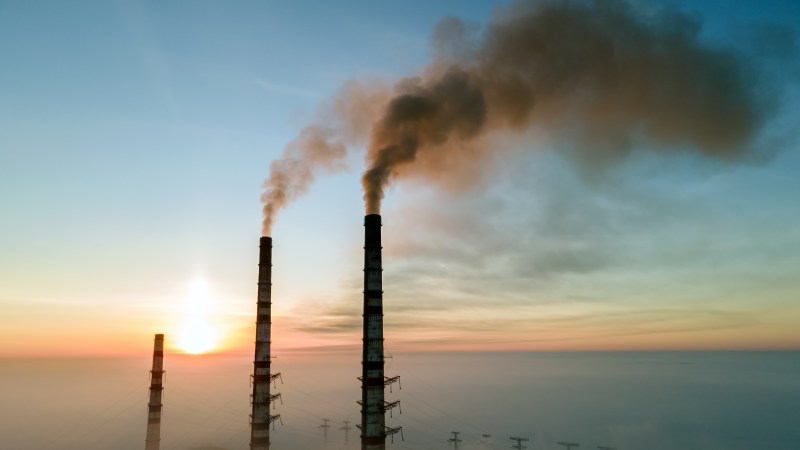 Blog Ambiental • Chaminés industriais liberando poluentes no pôr do sol