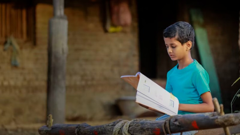 Blog Ambiental • Criança lendo em ambiente rural, representando a atuação das ONGs na defesa dos direitos ambientais por meio da educação.