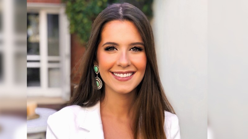 Jovem brasileira sorridente, vestindo blazer branco, símbolo da liderança jovem na luta pela justiça climática e pela sustentabilidade.