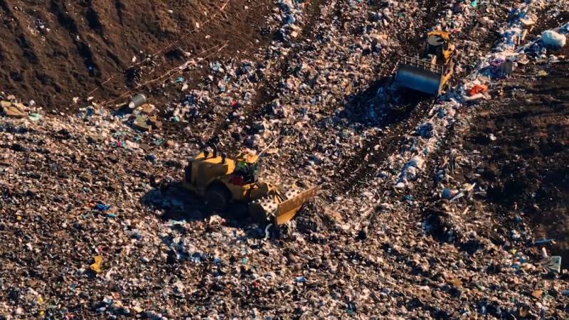 ratores compactadores operando sobre massa de resíduos em aterro sanitário — operação registrada na série O Lixo Também É Seu.