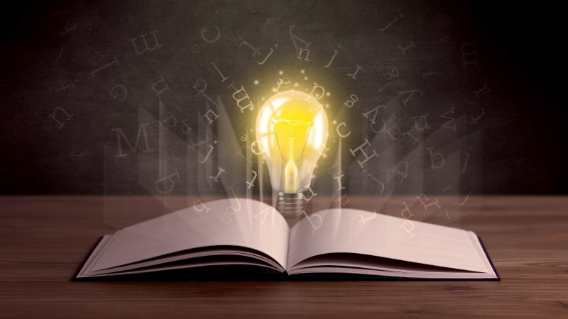 Blog Ambiental • Lâmpada acesa emergindo de um livro aberto