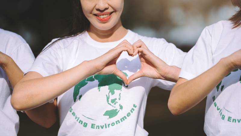Blog Ambiental • Pessoas vestindo camisetas ambientais formando um coração com as mãos, simbolizando engajamento e compromisso com o meio ambiente