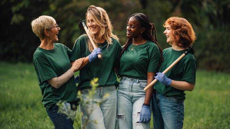 Grupo de mulheres realizando ação coletiva de preservação ambiental e cuidado com áreas verdes.