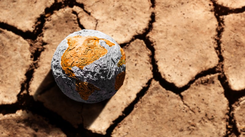 Blog Ambiental • Planeta Terra sobre solo rachado simbolizando escassez hídrica e colapso ambiental